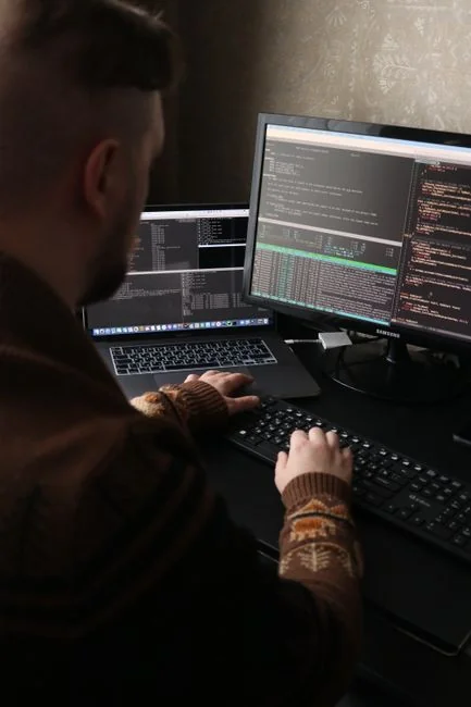 A modern workspace featuring dual computer monitors displaying web design projects, emphasizing technology and productivity.